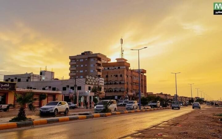 Avenida com veículos e edifícios na cidade de Ataq, na província iemenita de Shabwa, ao entardecer.