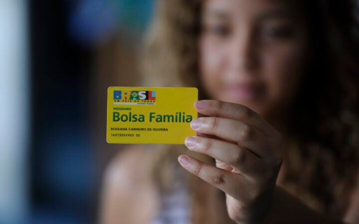 Cartão do Bolsa Família segurado por uma mulher, em fotografia de arquivo.