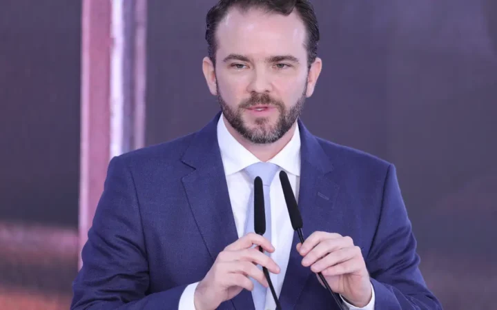 Dario Durigan fala diante de dois microfones