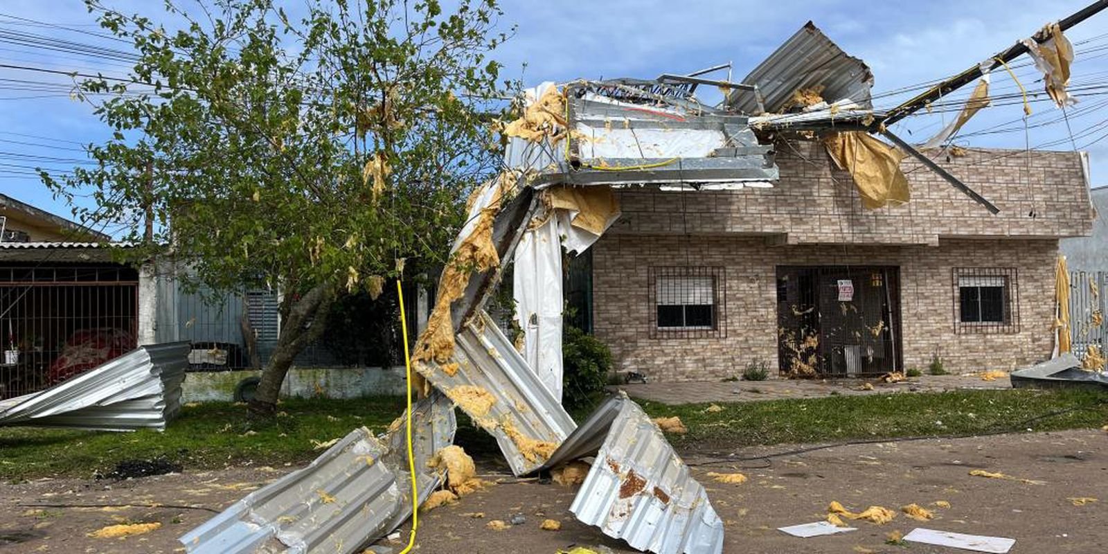 Casa e árvores danificadas após temporal, em fotografia de divulgação de arquivo.