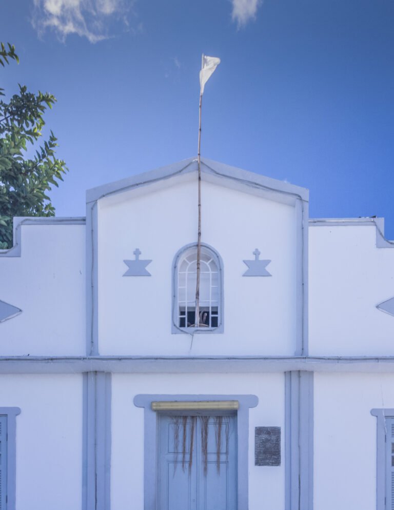 Fachada branca do Terreiro do Gantois, em Salvador, com bandeira no alto.