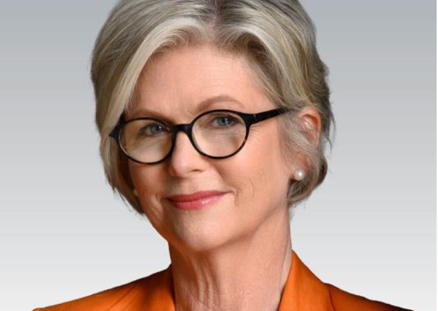 Retrato de Helen Haines usando blazer laranja.
