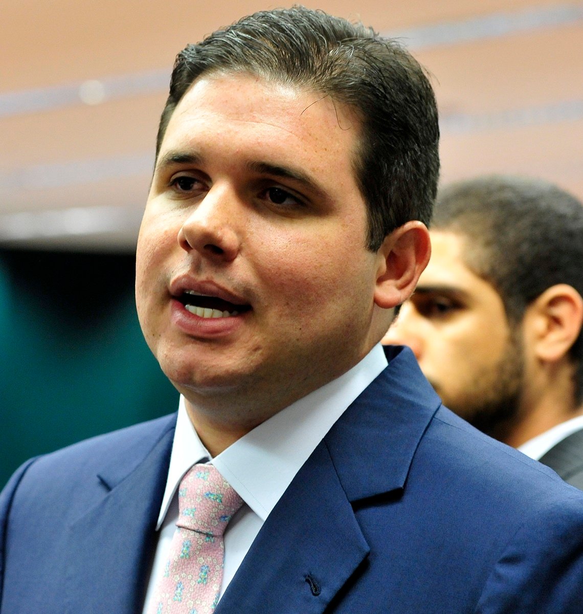 Hugo Motta de terno azul fala na Câmara dos Deputados.