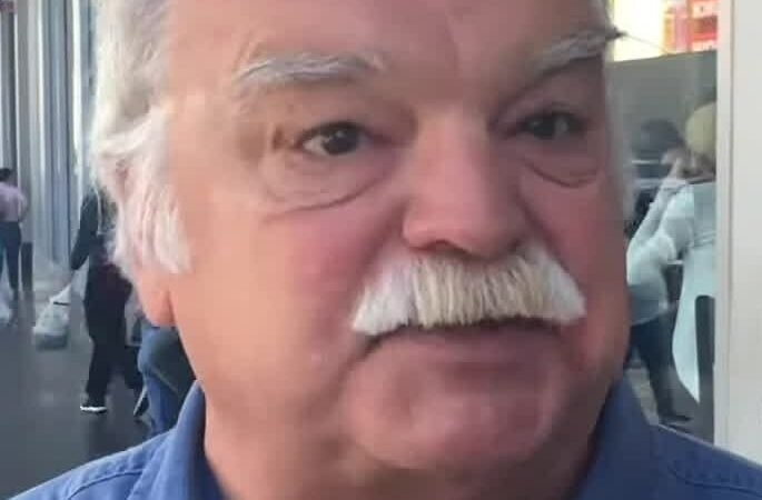 Richard Riehle, de camisa azul e bigode branco, em registro de 2016