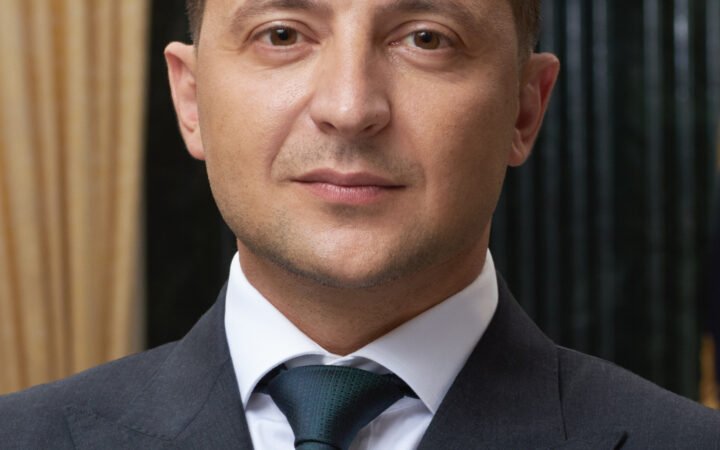 Volodymyr Zelensky em retrato oficial de terno escuro e gravata.